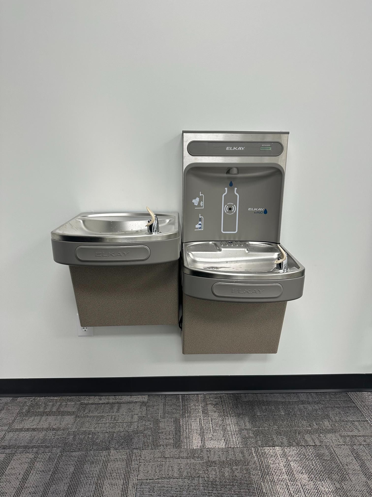 Water fountain combo unit on a wall. The unit has a drinking fountain and a water bottle filling station.