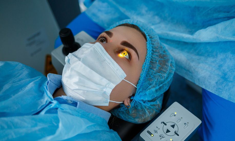 A surgeon is looking through a microscope at a patient's eye