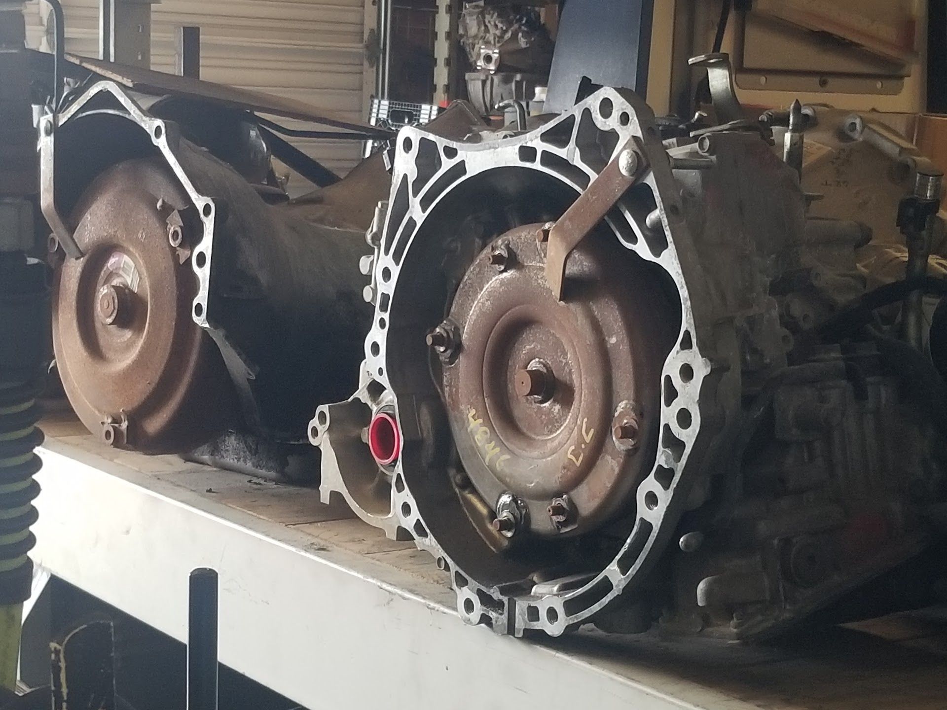Two car transmissions, one open, showing rusty torque converter | Riley Auto Care & Transmissions