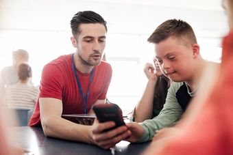 man helping teen with phone