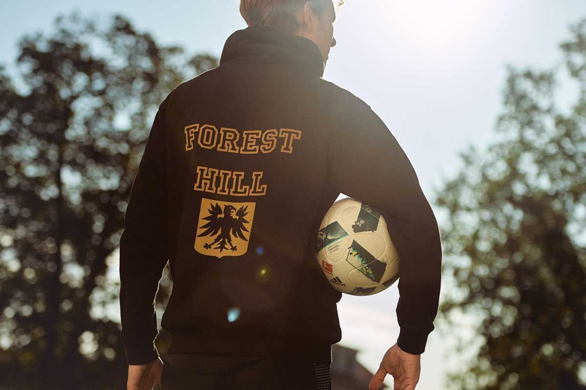 En man i en Forest Hill-tröja håller en fotboll.