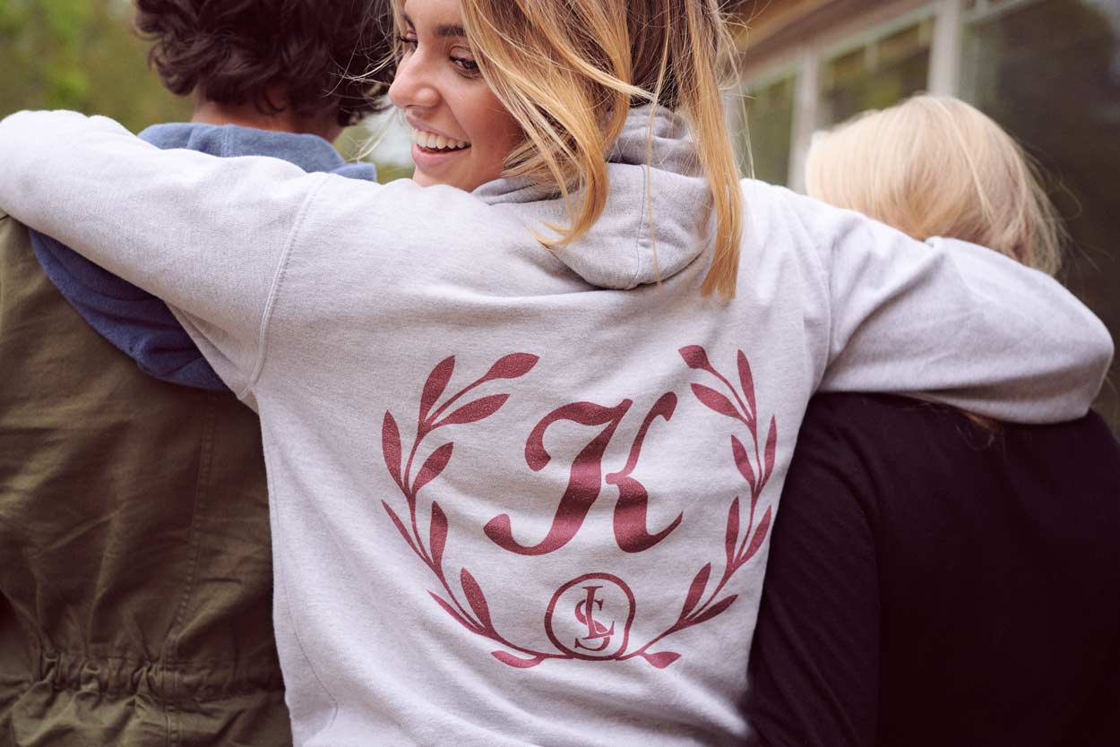 En kvinna som bär en luvtröja med bokstaven k på