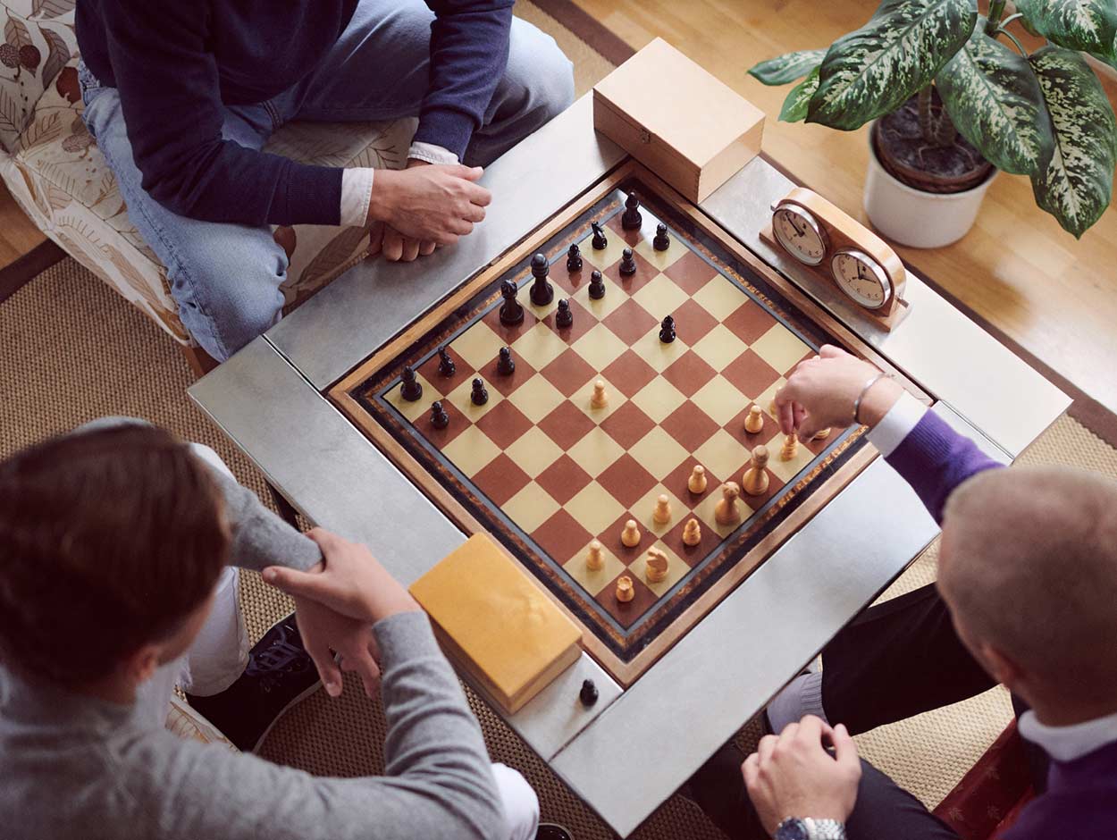 En grupp människor spelar schack på ett bord.