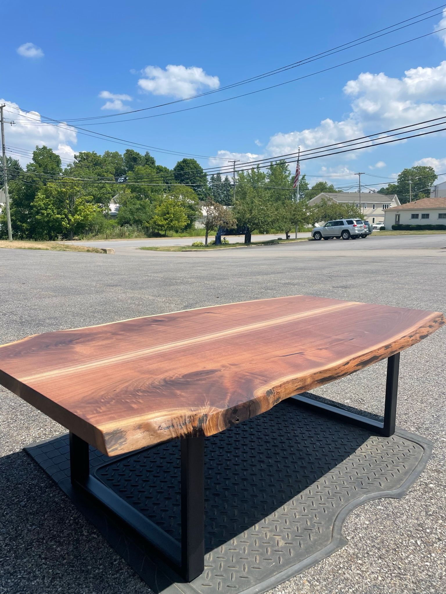 A wooden table is sitting on the ground in a parking lot.