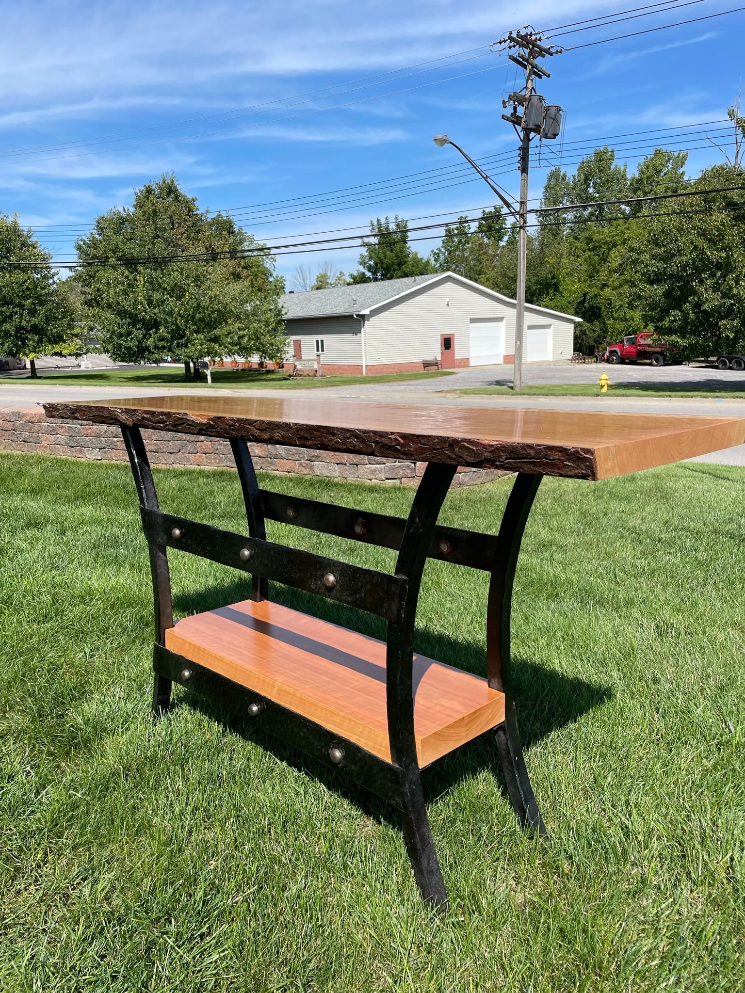A wooden table is sitting on top of a lush green field.