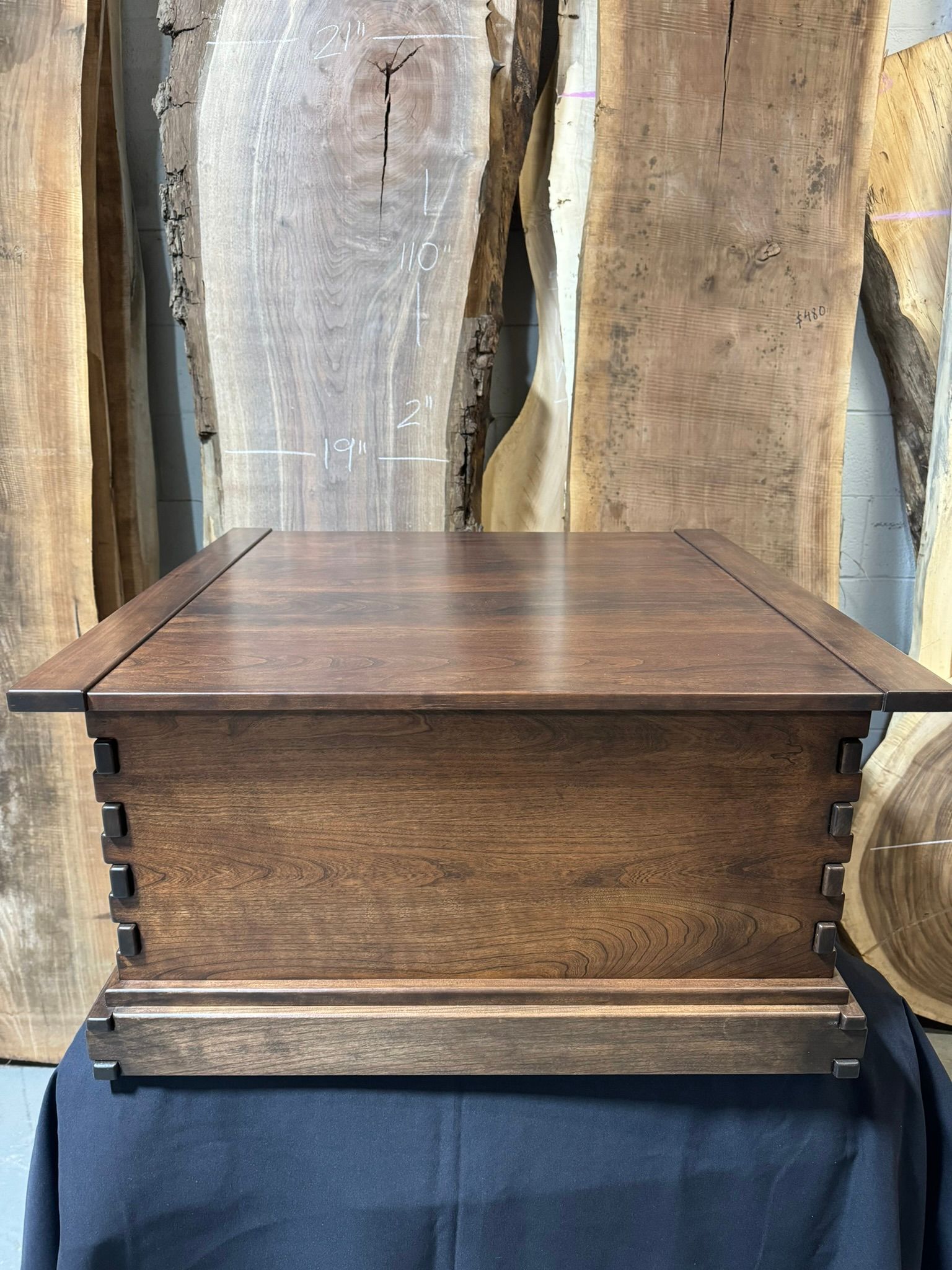 A wooden box is sitting on top of a black cloth on a table.