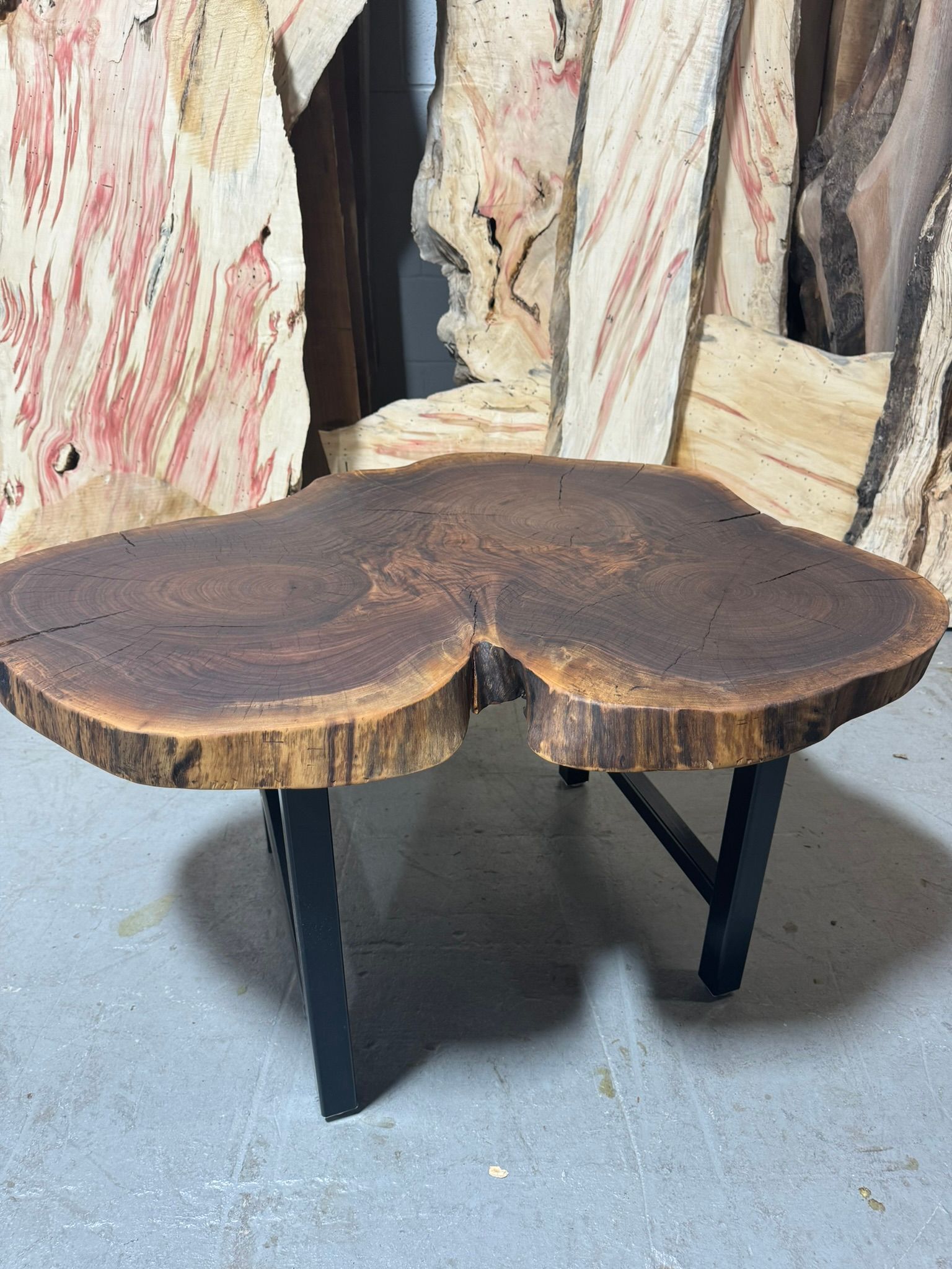 A wooden table with a slice of wood on top of it.