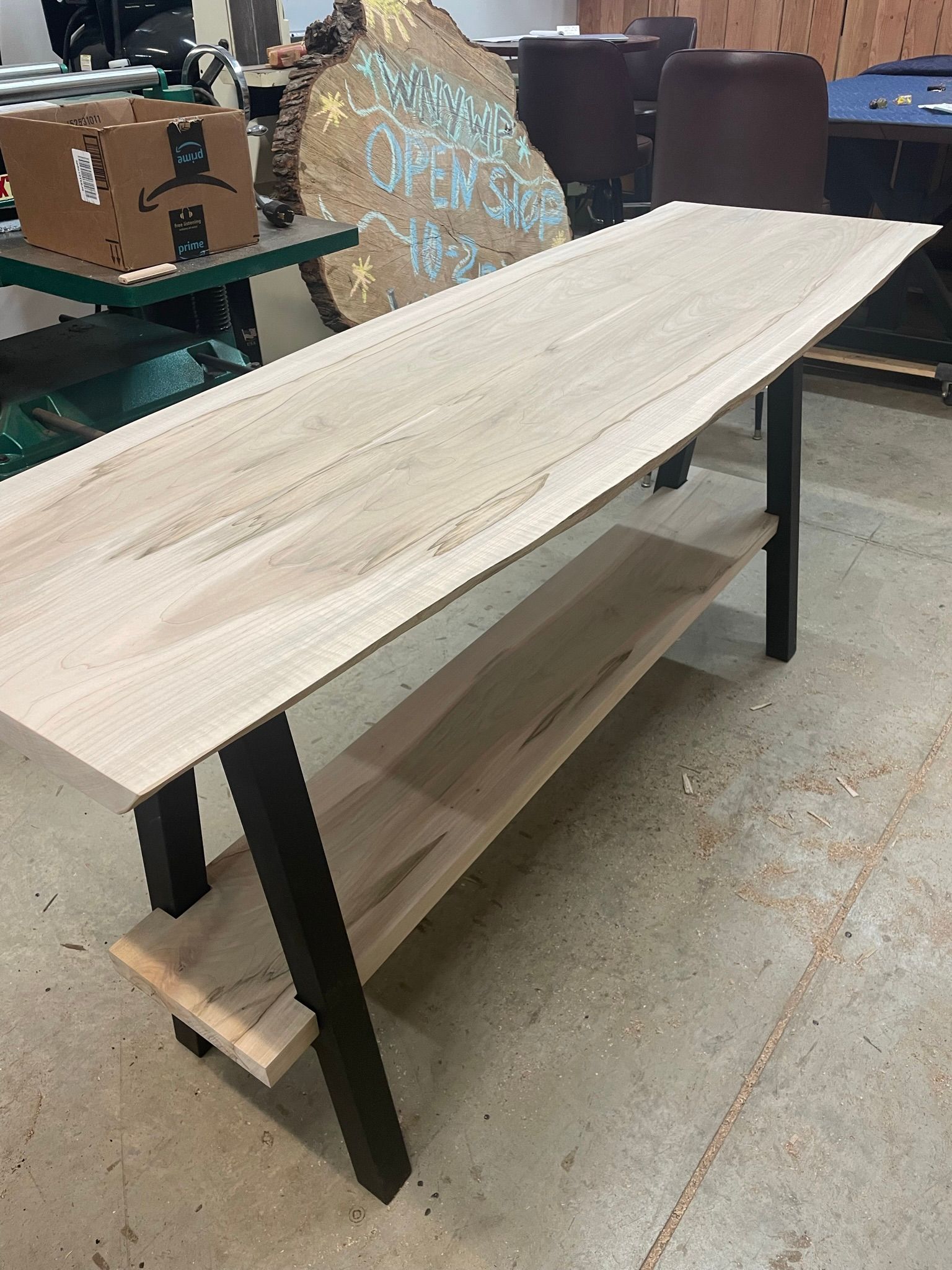A wooden table with a shelf underneath it in a room.
