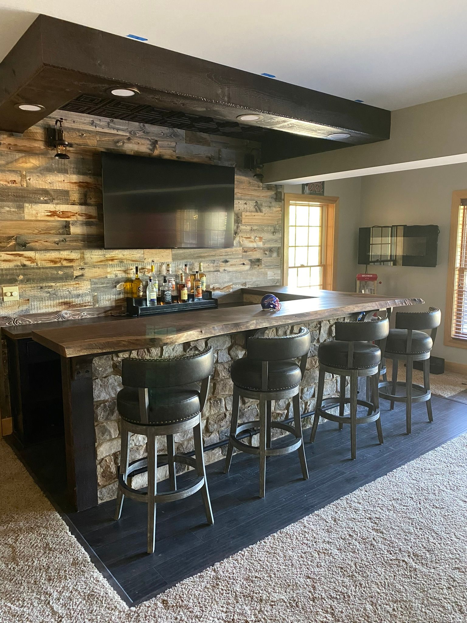 A bar with stools and a television in a living room.