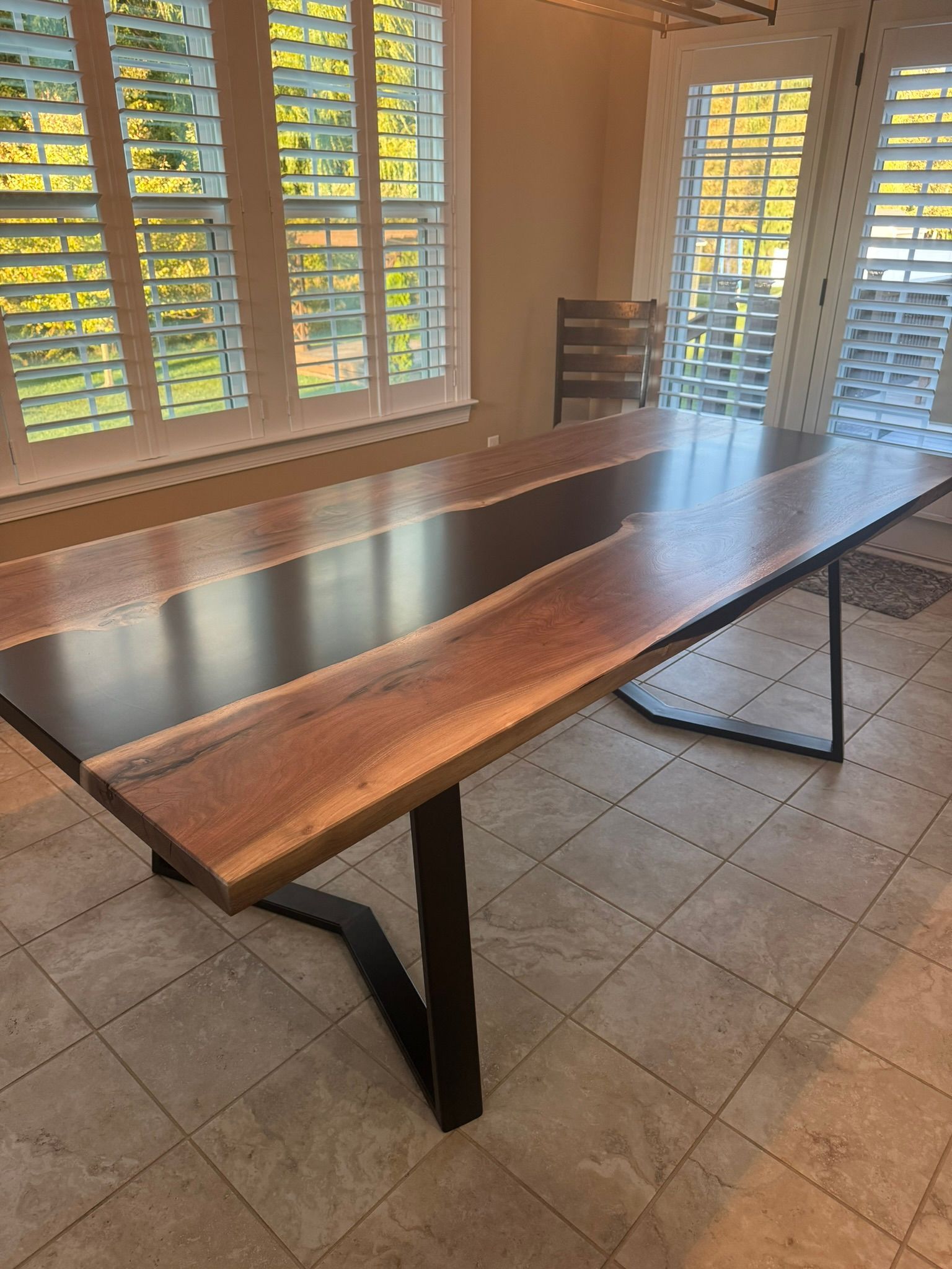 A wooden table is sitting in a room next to a window.