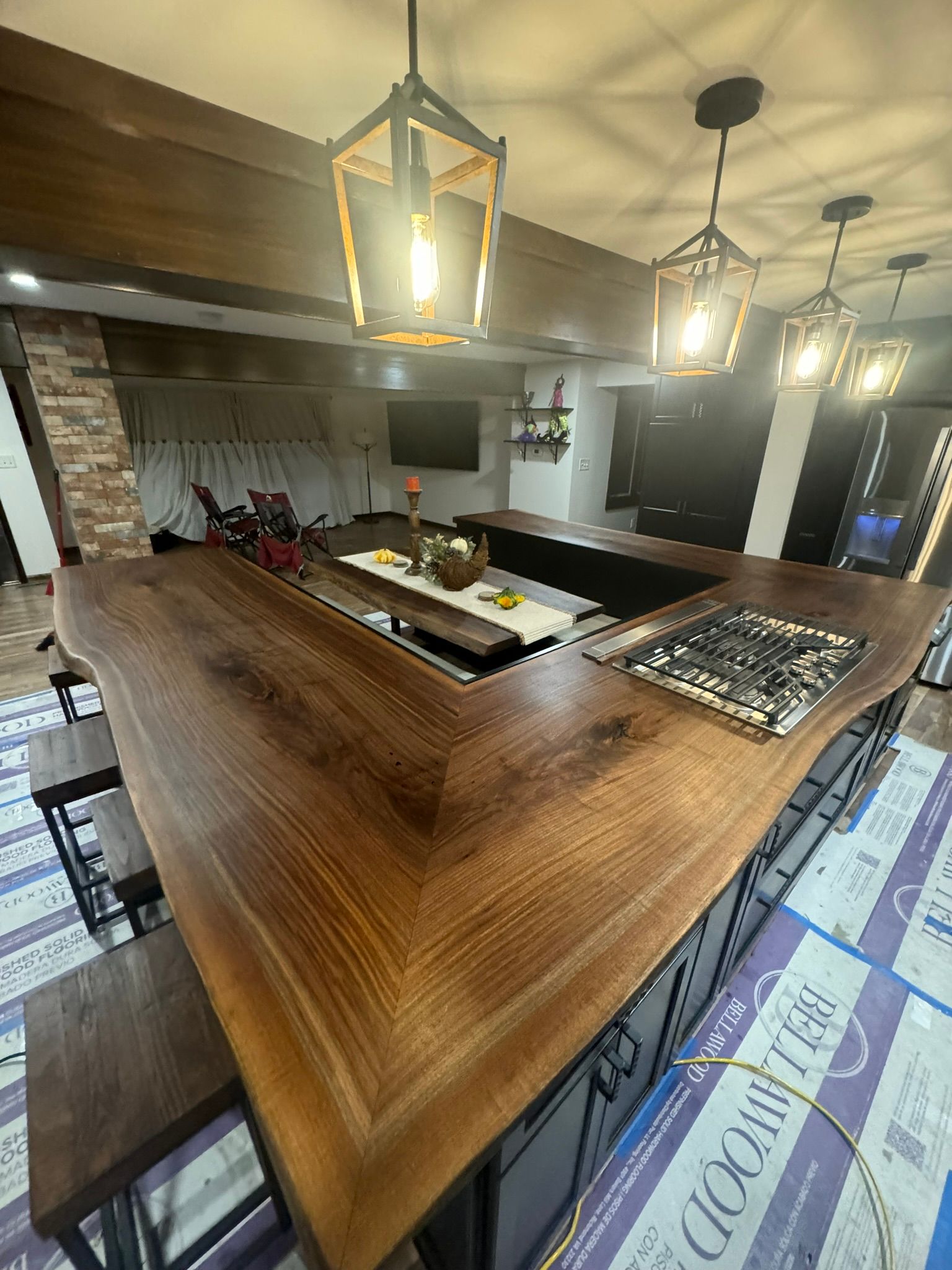 A kitchen with a large wooden counter top and a stove top oven.