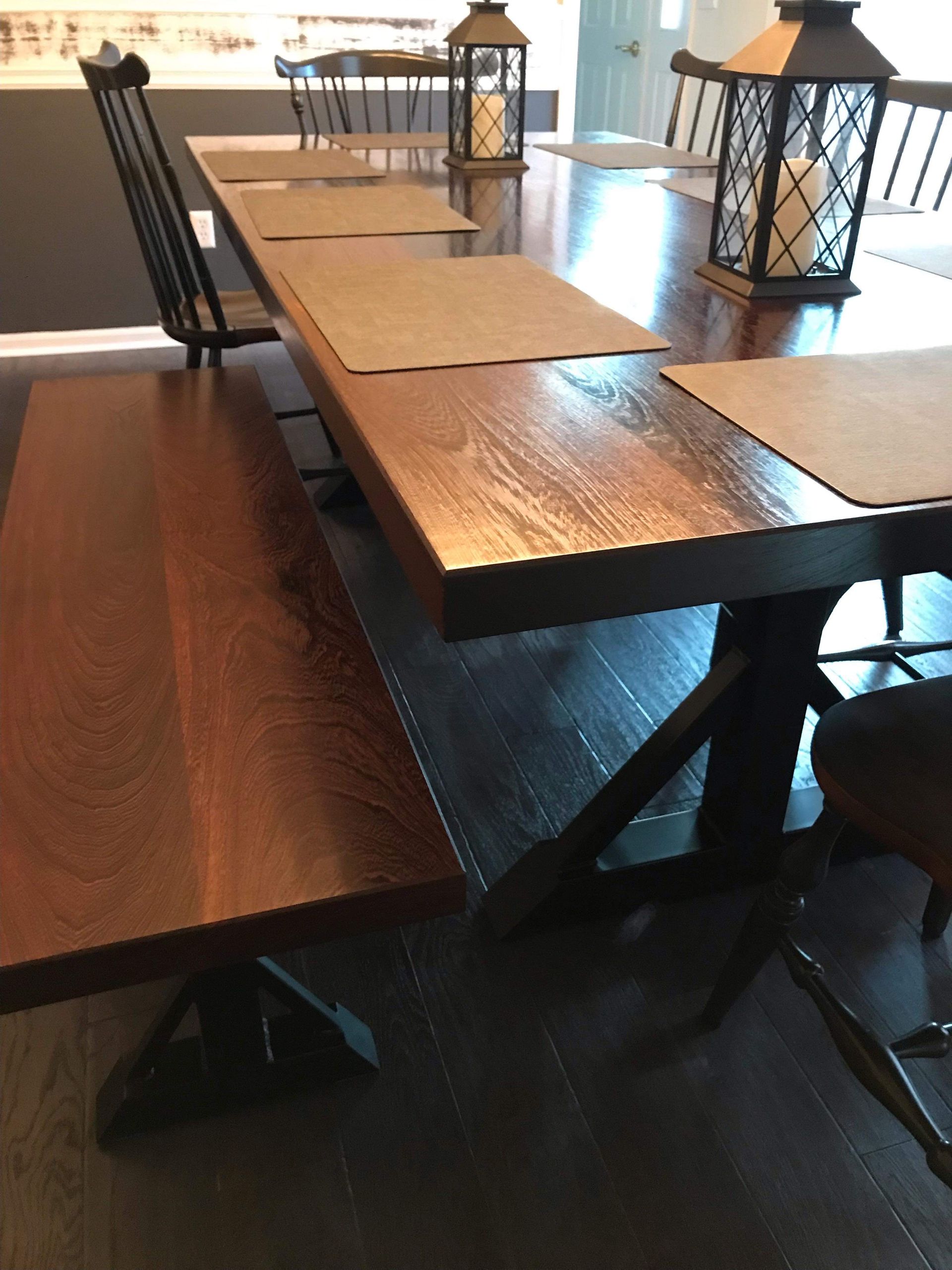 A dining room table with a bench and chairs