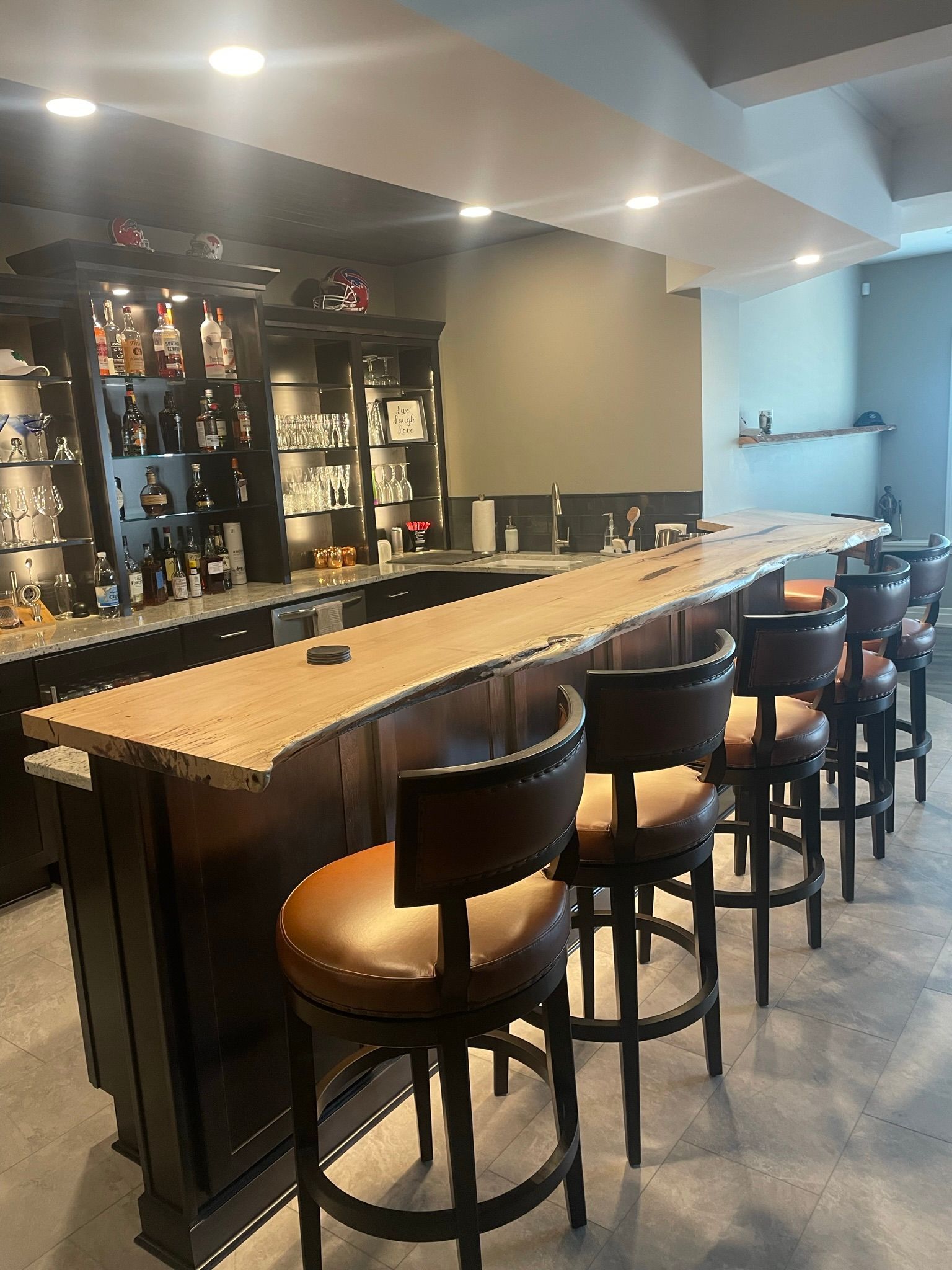 A bar with a long counter and chairs in a basement.