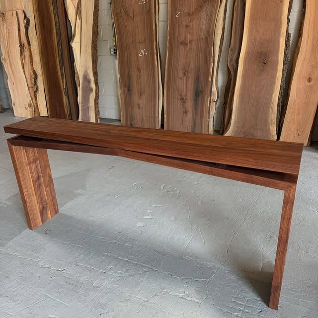 A wooden bench is sitting in front of a wall of wood