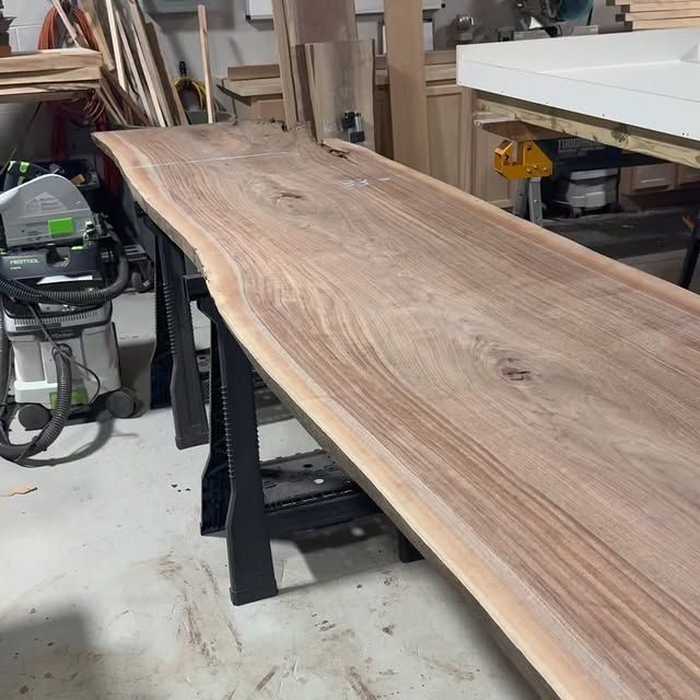 A wooden table with a vacuum cleaner in the background