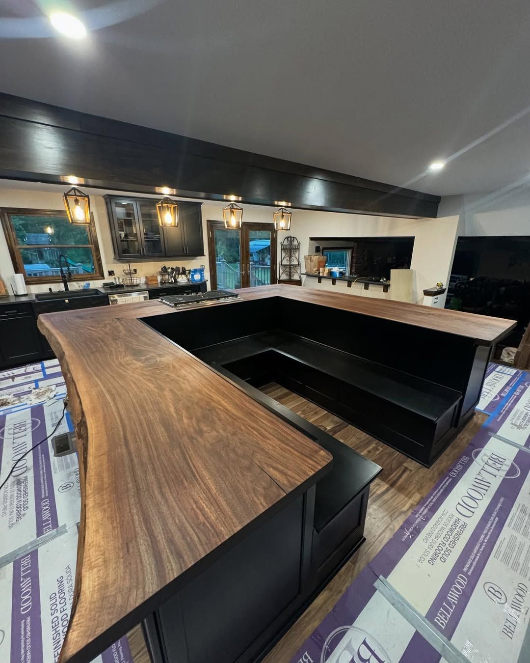 A kitchen with a wooden counter top and a black couch.