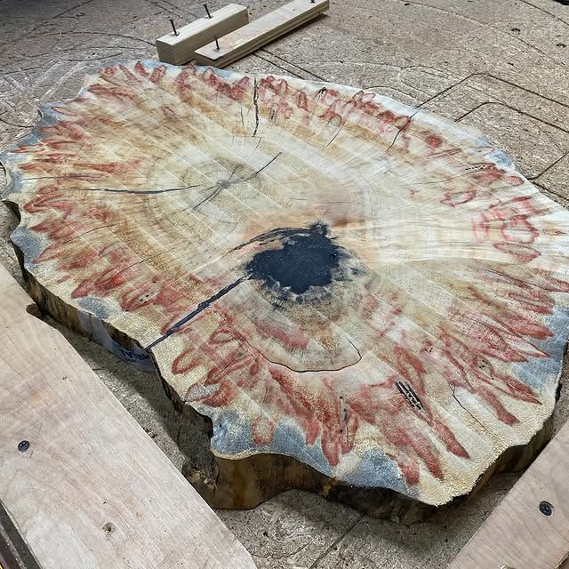A large piece of wood is sitting on top of a wooden table.