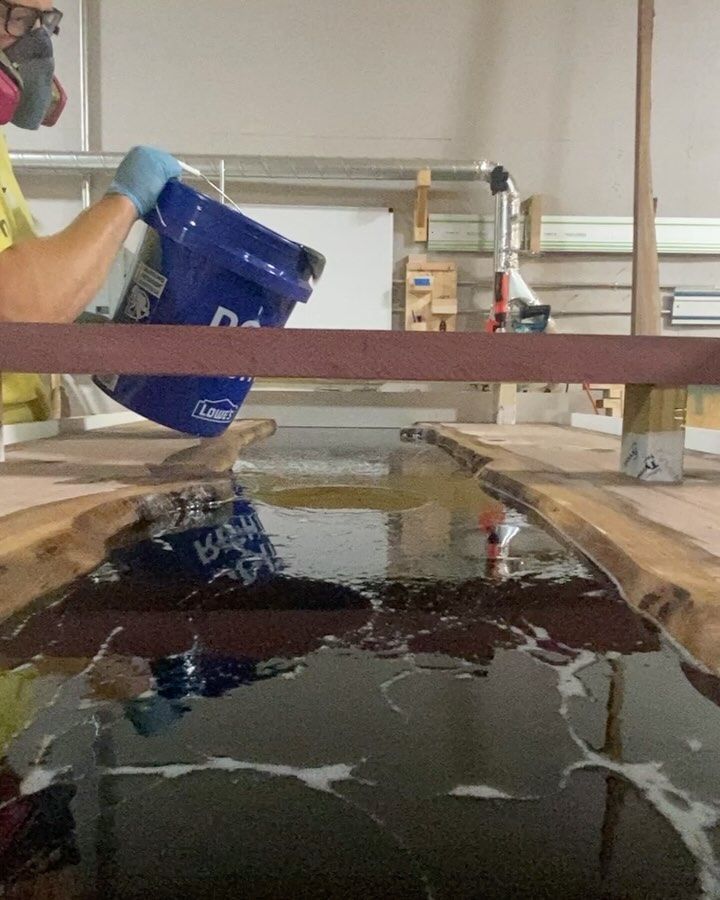 A person is pouring a blue bucket into a pool of water