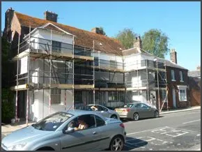 old house on a busy road with scaffolding around it