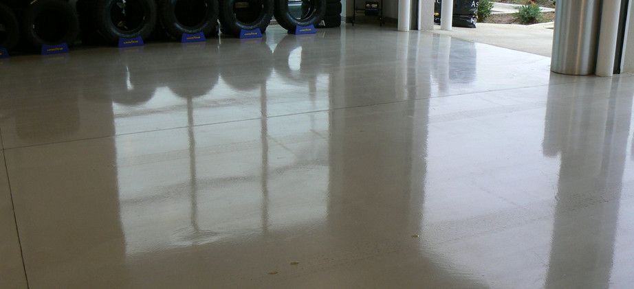 A Shiny White Tiled Floor in A Room with A Lot of Tires in The Background - Tuscaloosa, AL - Jeffco Concrete Contractors