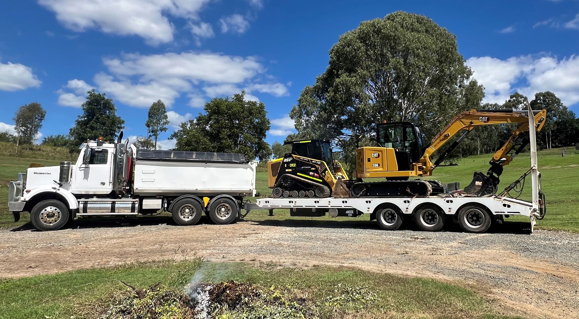 a Large Orange Bulldozer is Transported on a Flatbed Trailer — Damon's Earthworks in Chatsworth, QLD