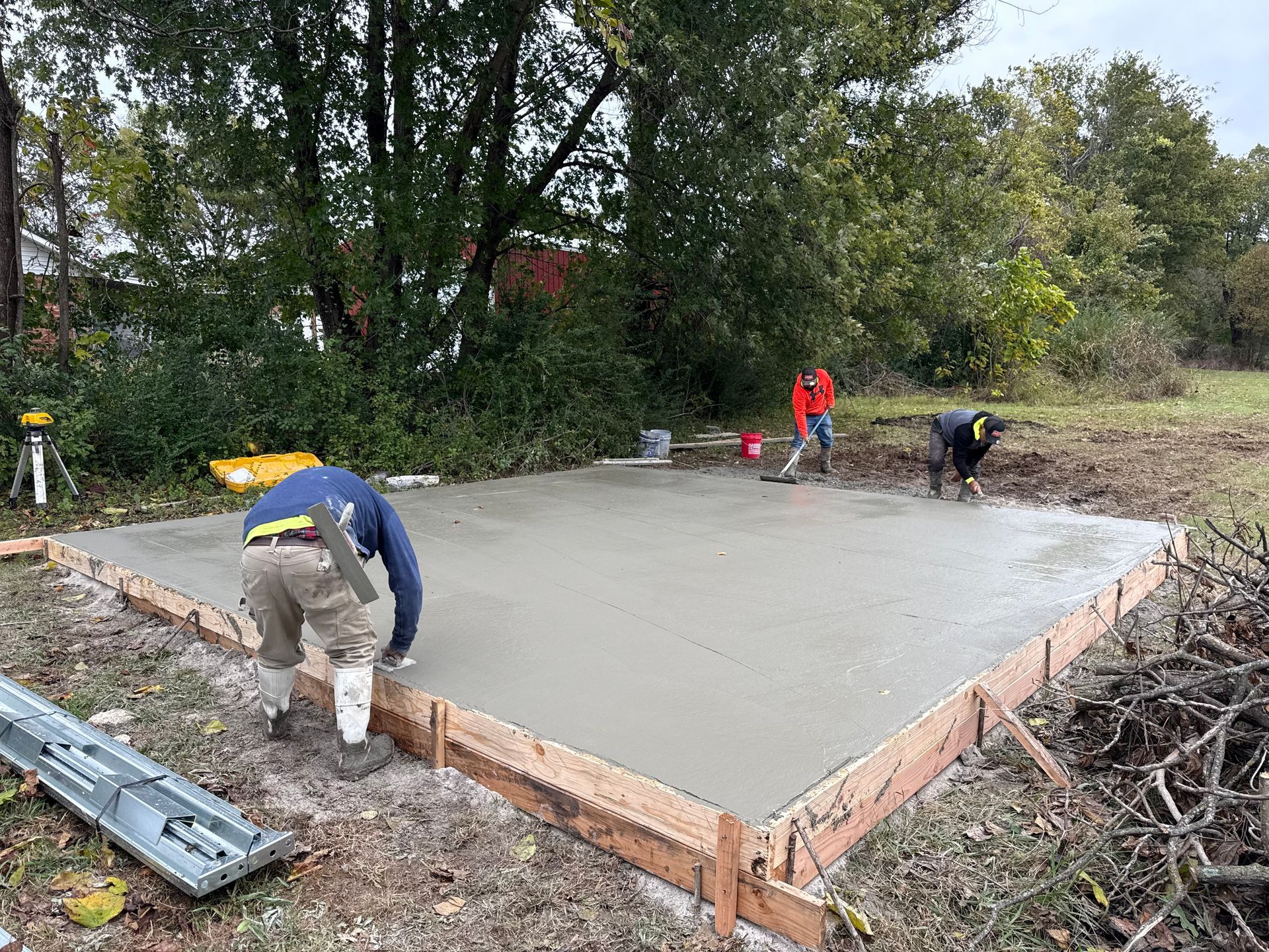 Workers pouring concrete slab for building construction outdoors.