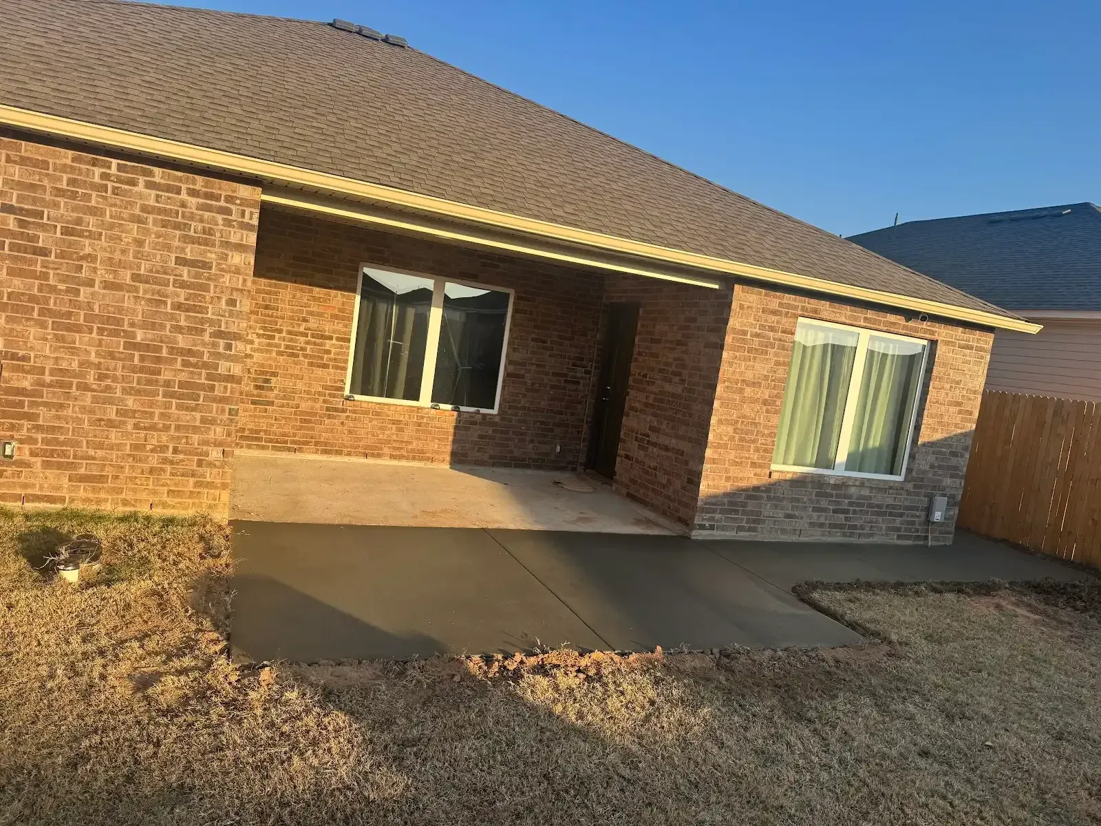 Brick house with new concrete patio and windows.