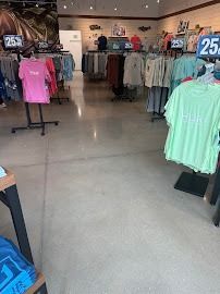 Clothing store interior with racks of shirts, a polished concrete floor.