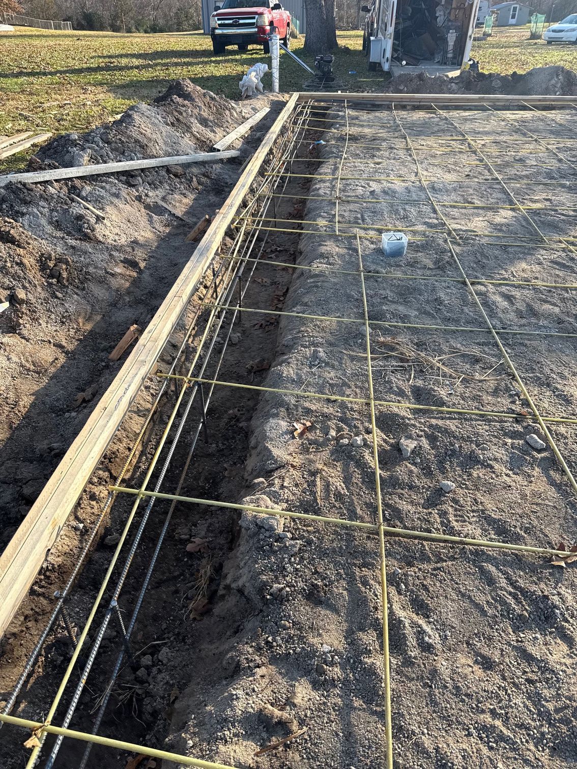 Construction site: rebar grid laid in a trench, prepared for concrete pouring.