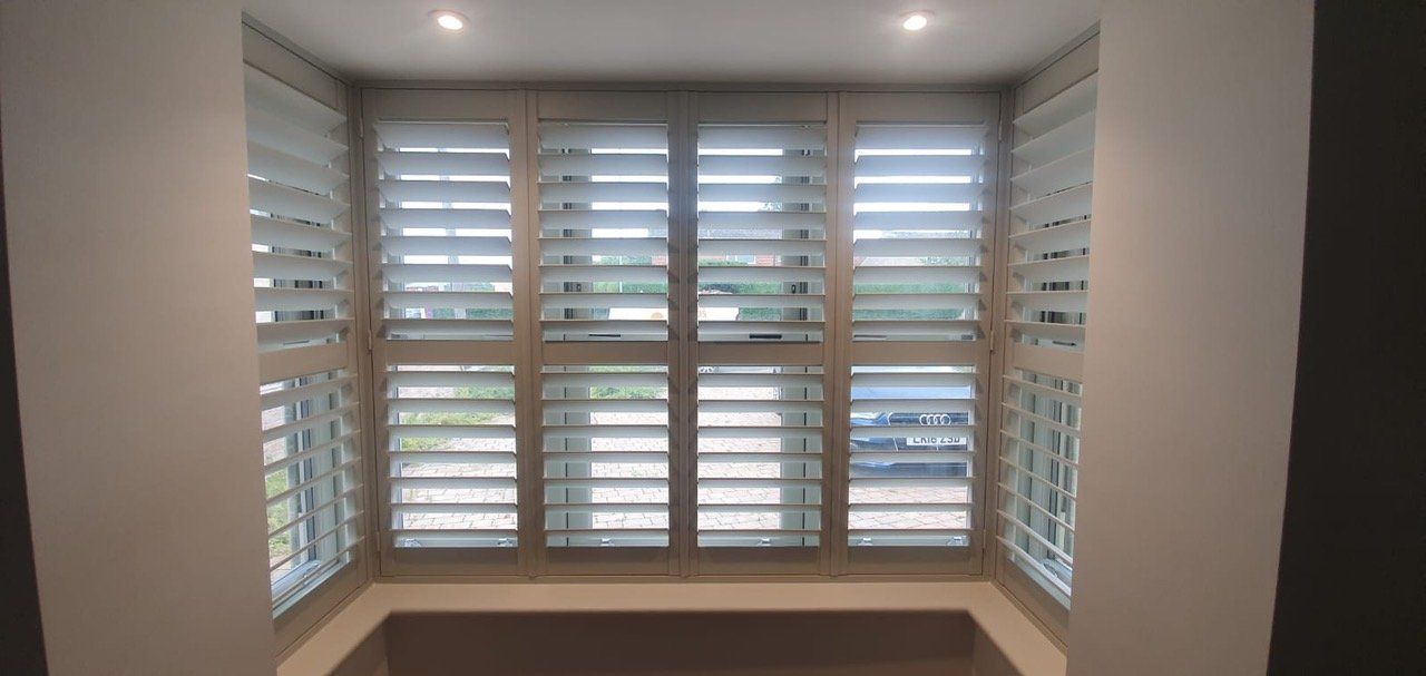 A room with a window with shutters on it