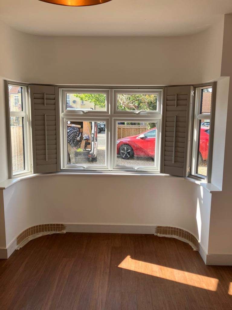 There is a red car parked in front of the window.