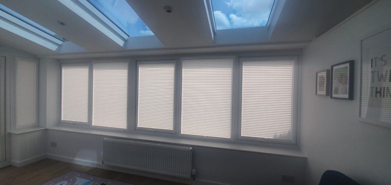 A living room with a lot of windows and a skylight.