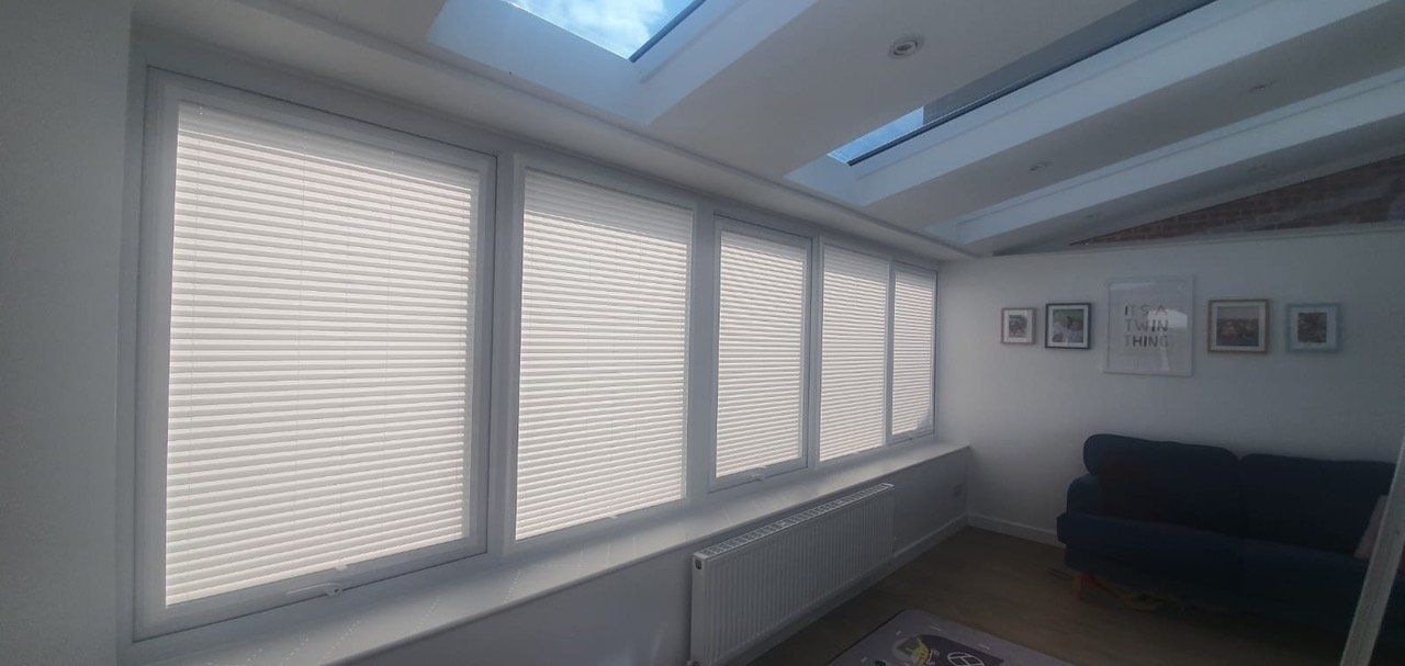 A living room with a couch and a skylight above the windows.