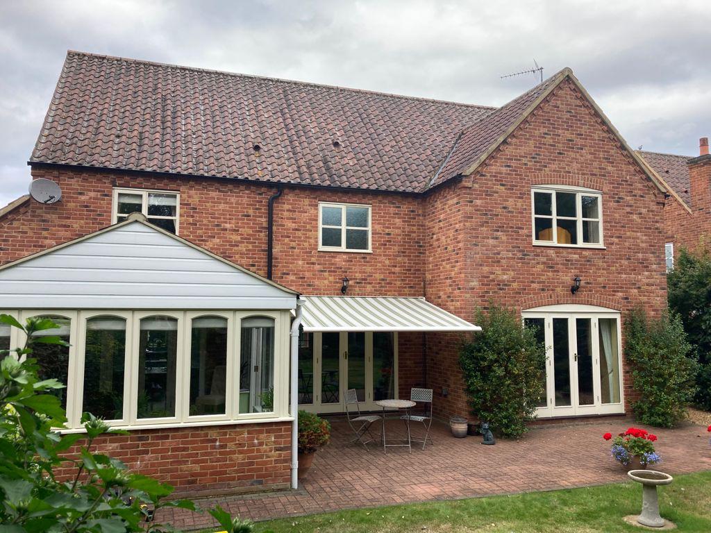 A large brick house with a white awning on the side of it.