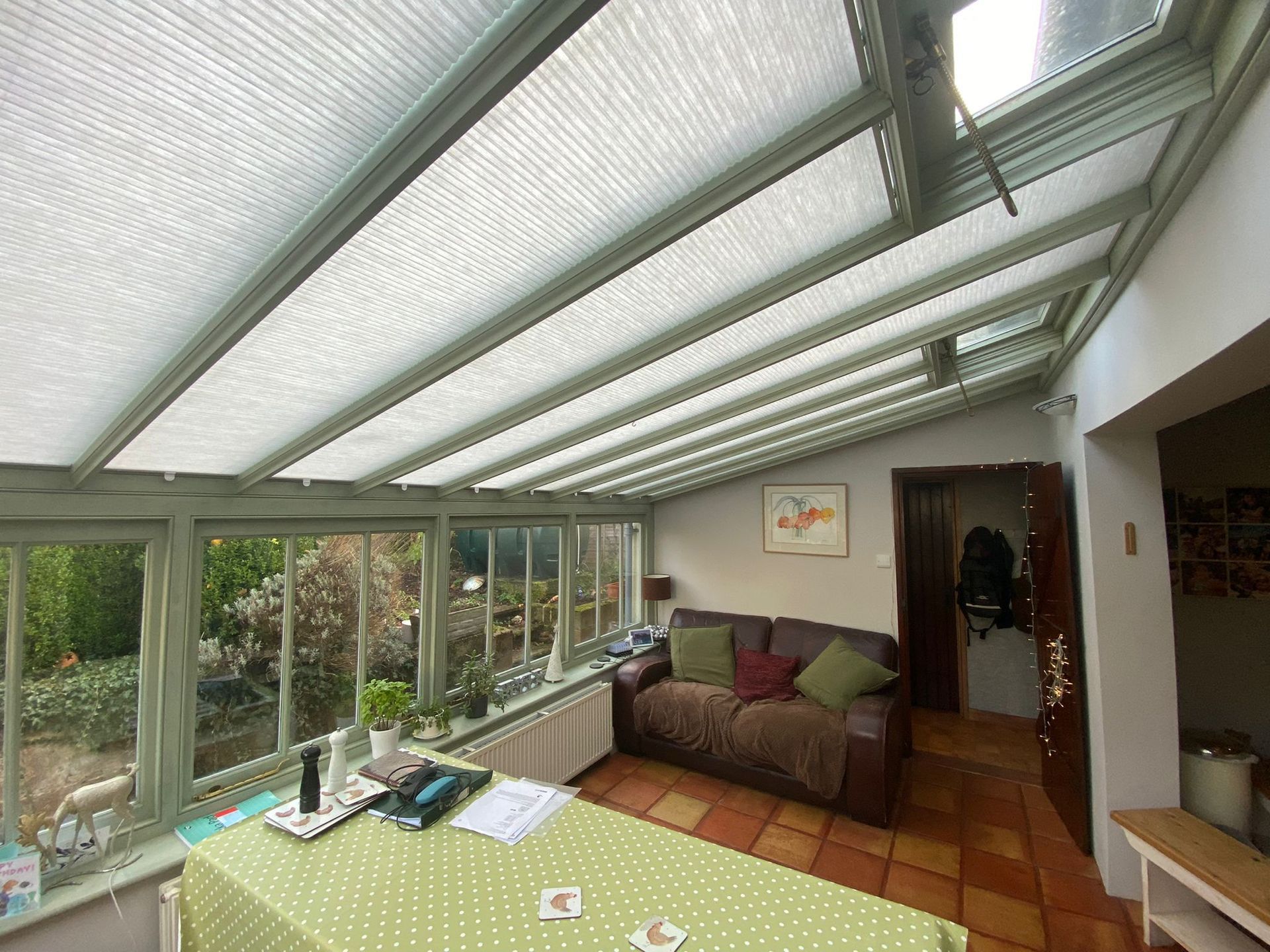 A living room with a couch and a table in a conservatory.
