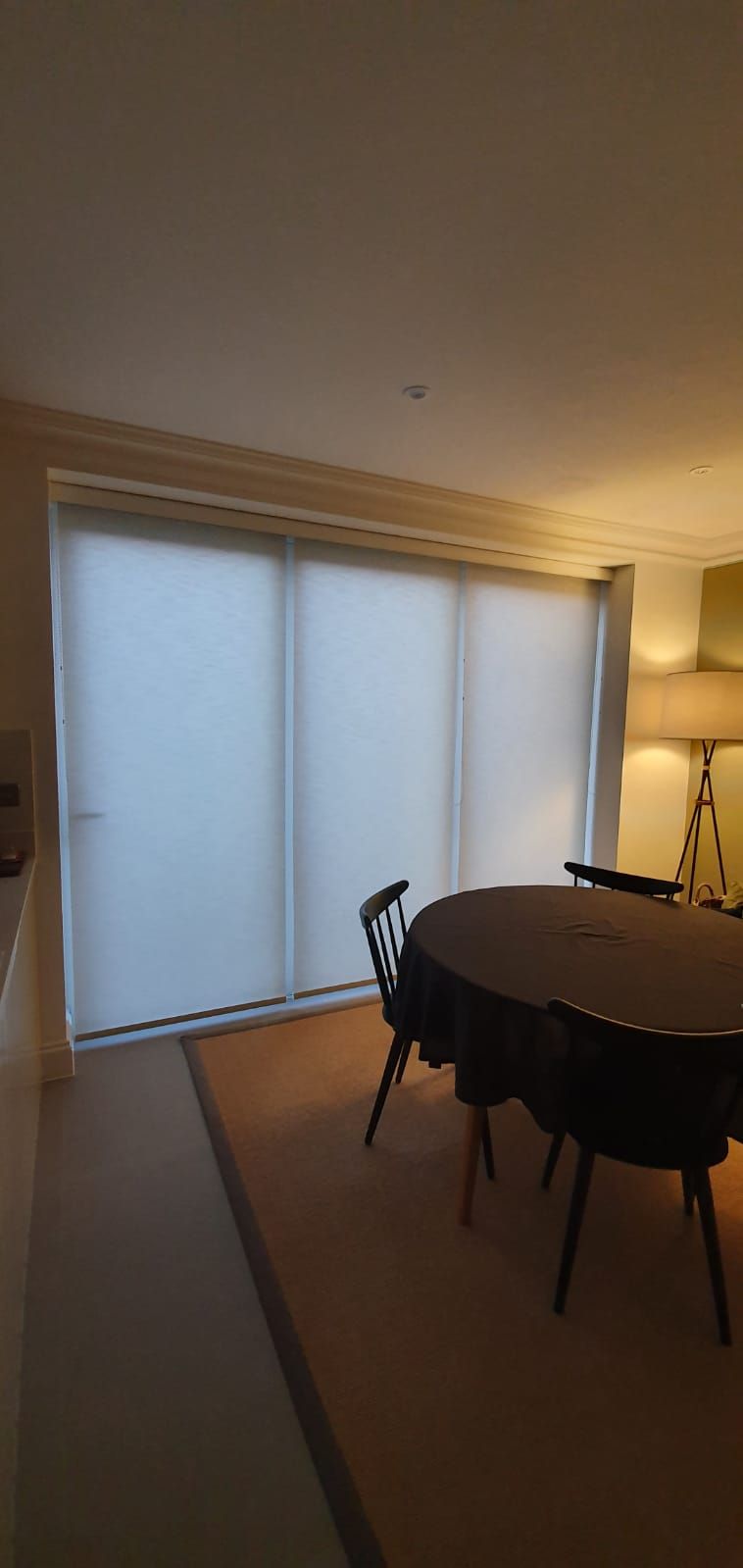 A dining room with a table and chairs and sliding glass doors.