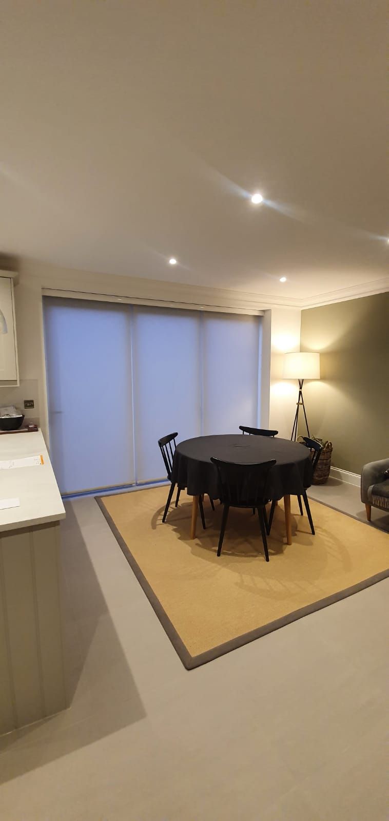 A dining room with a table and chairs and a rug.