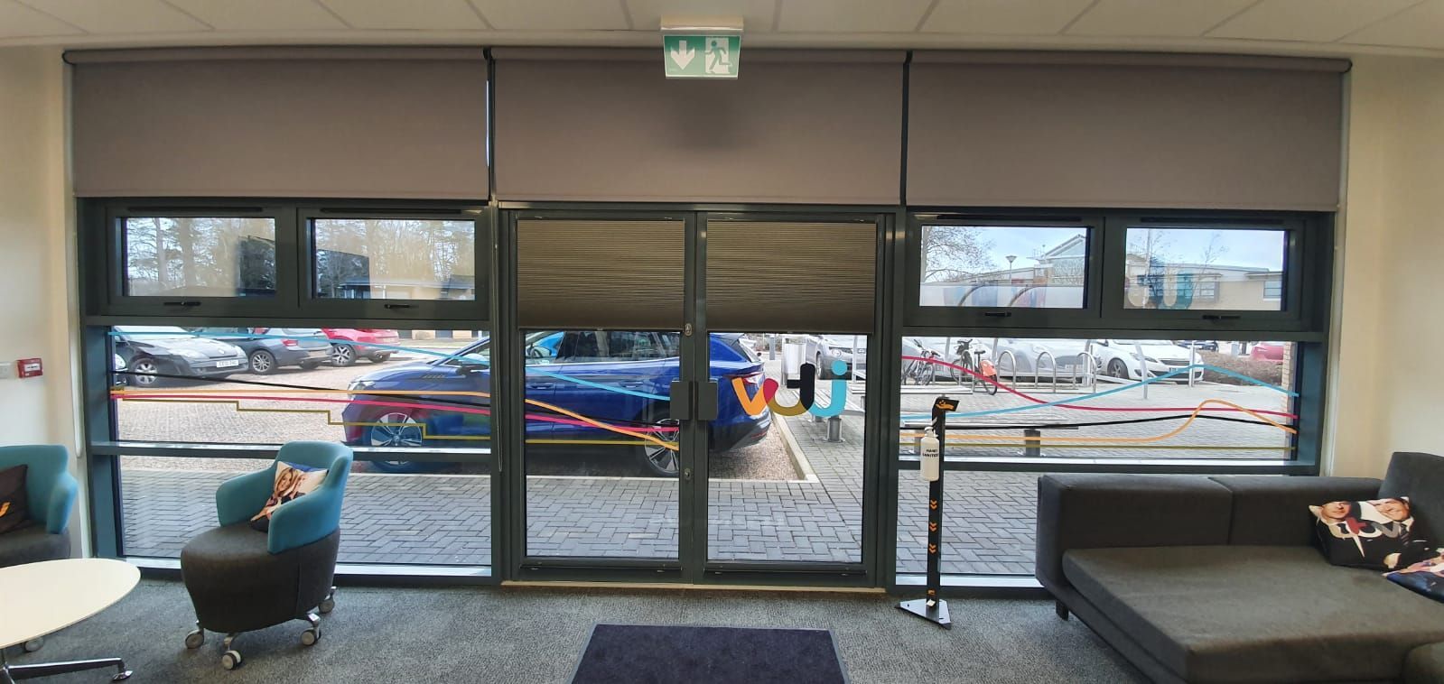 A living room with a couch , chairs , and a large window.