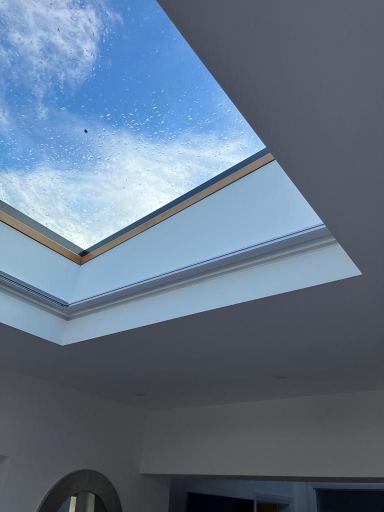 Looking up at the sky through a skylight in a room.