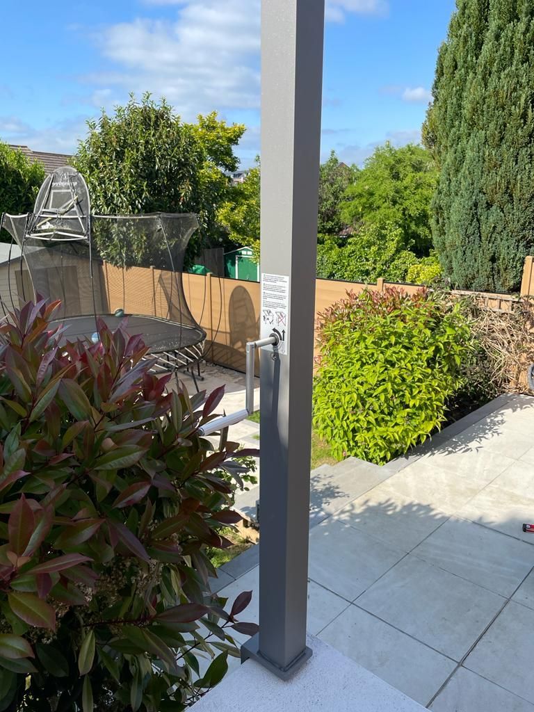 A patio with a shower in the middle of it.
