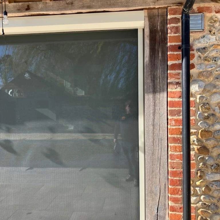 A brick wall with a screen door on it
