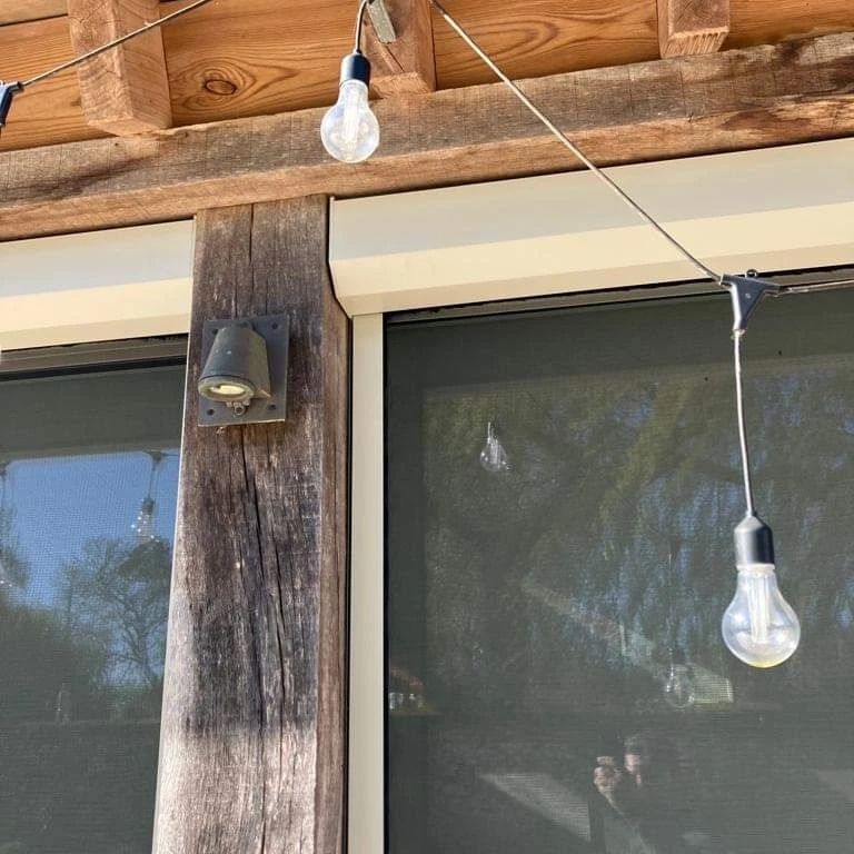 A string of light bulbs hanging from a wooden structure