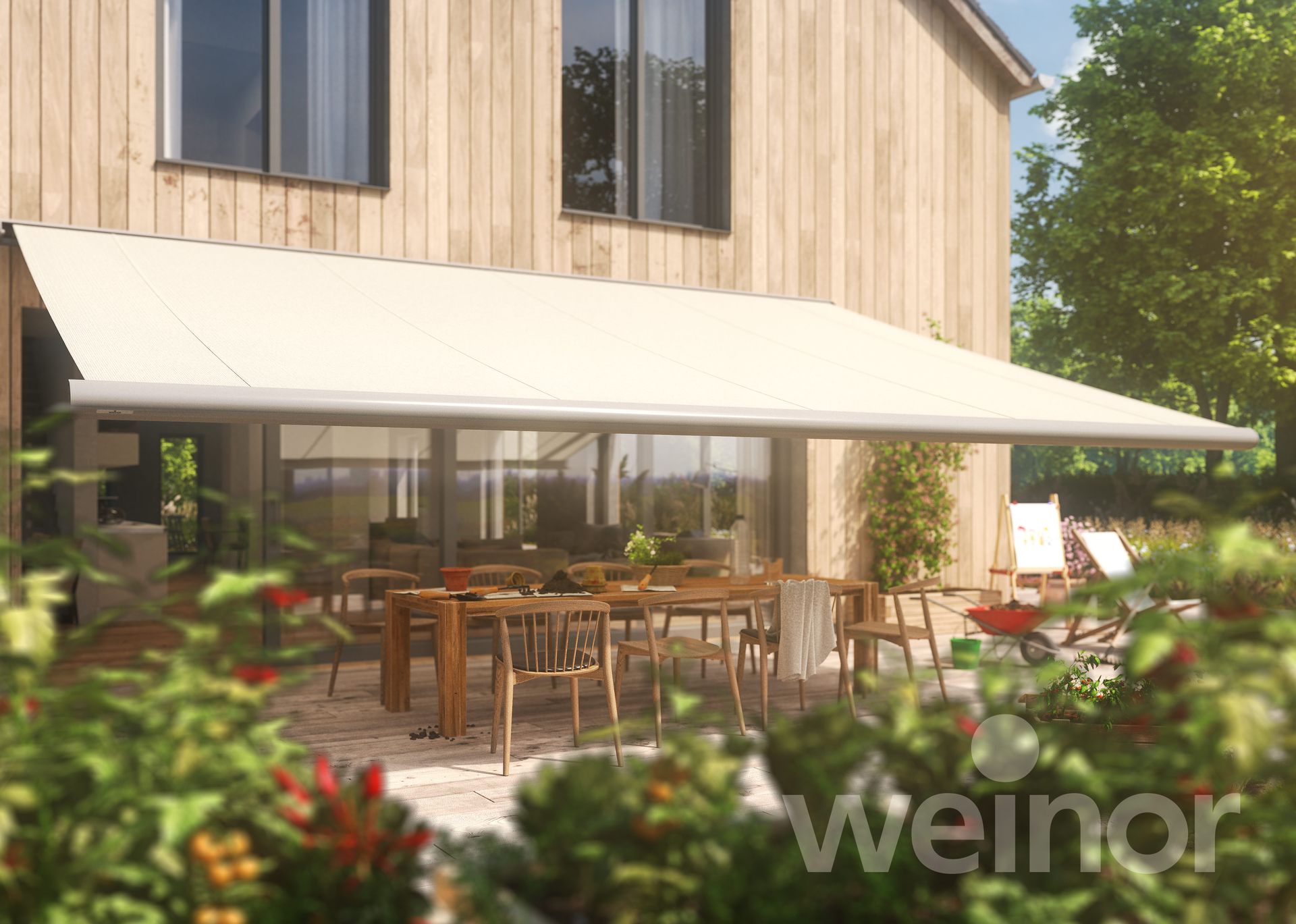 A wooden house with a white awning over a patio with tables and chairs.