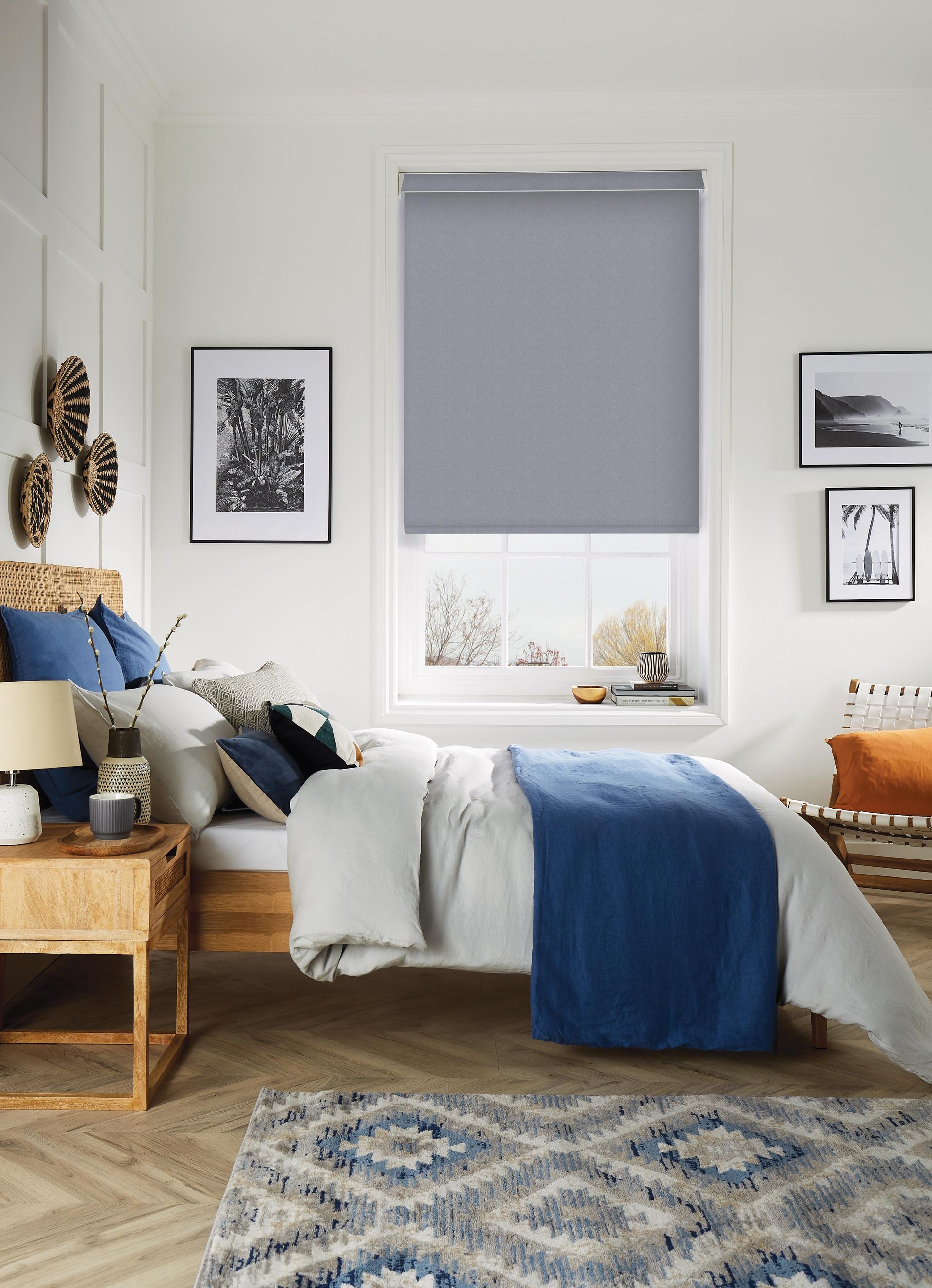 A bedroom with a bed , nightstand , rug and window.