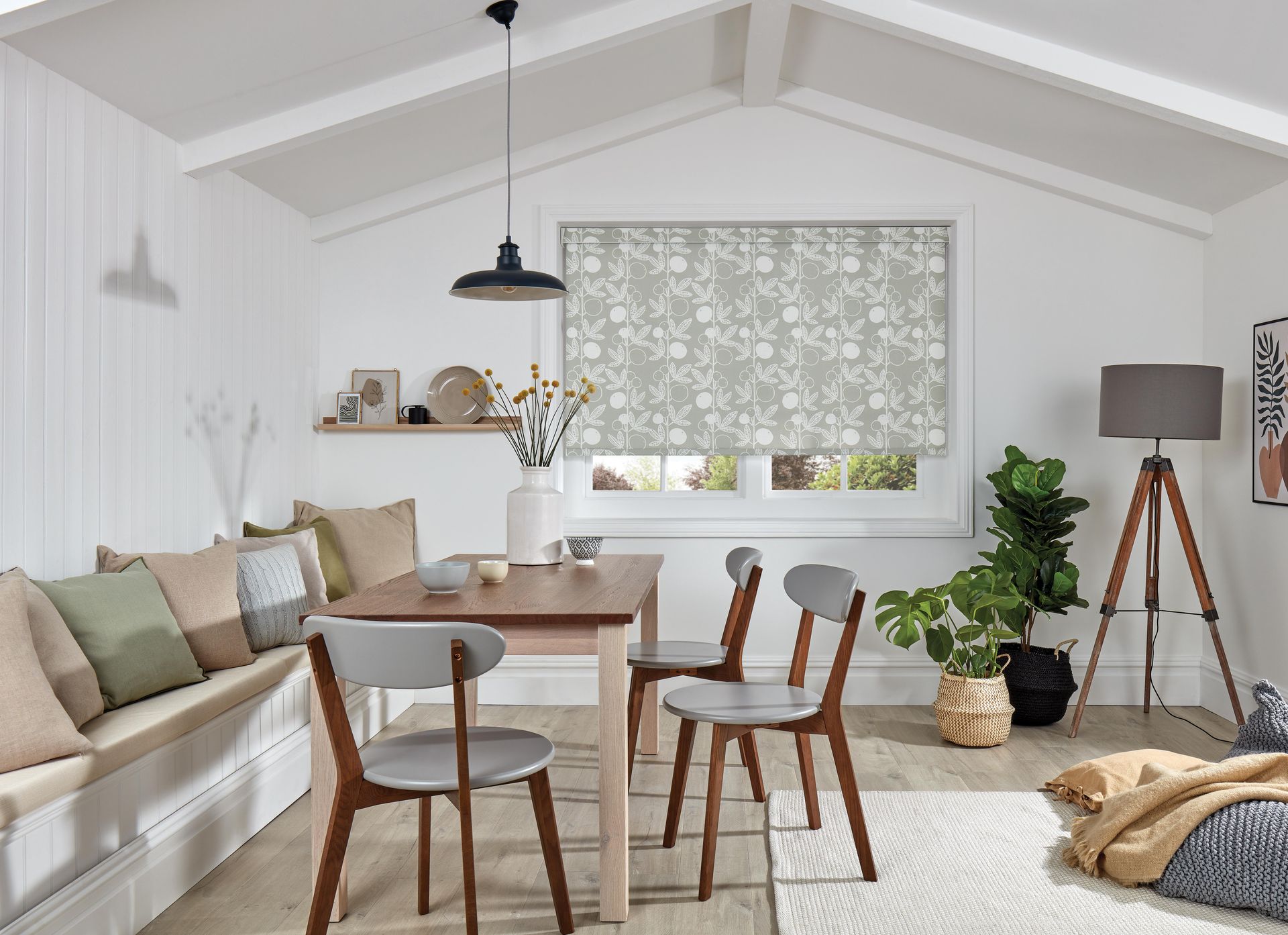 A living room with a table and chairs and a window.