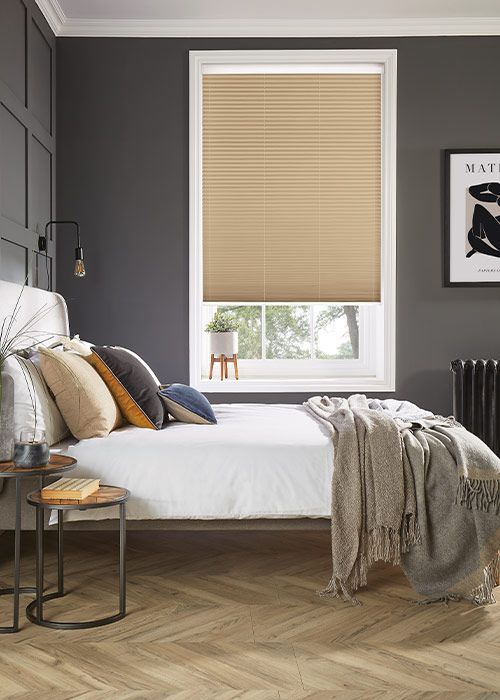 A bedroom with a bed and a window with blinds.