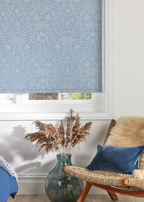 A living room with a chair and a vase of flowers.