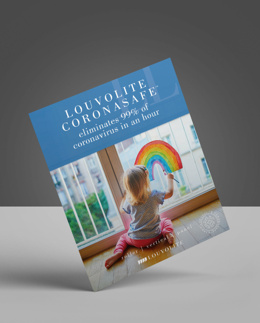 A child is sitting on the floor holding a rainbow in front of a window.