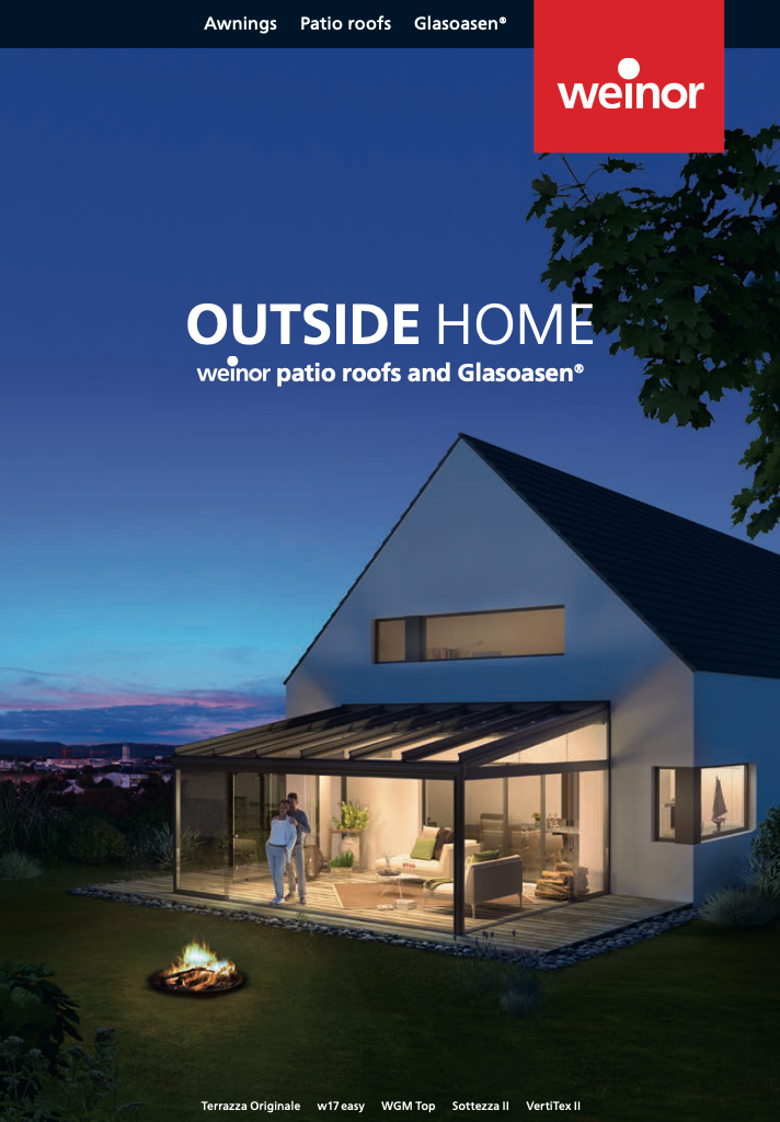 A white house with a patio roof and a fire pit in front of it.