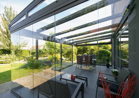 A patio with a glass roof and sliding glass doors.